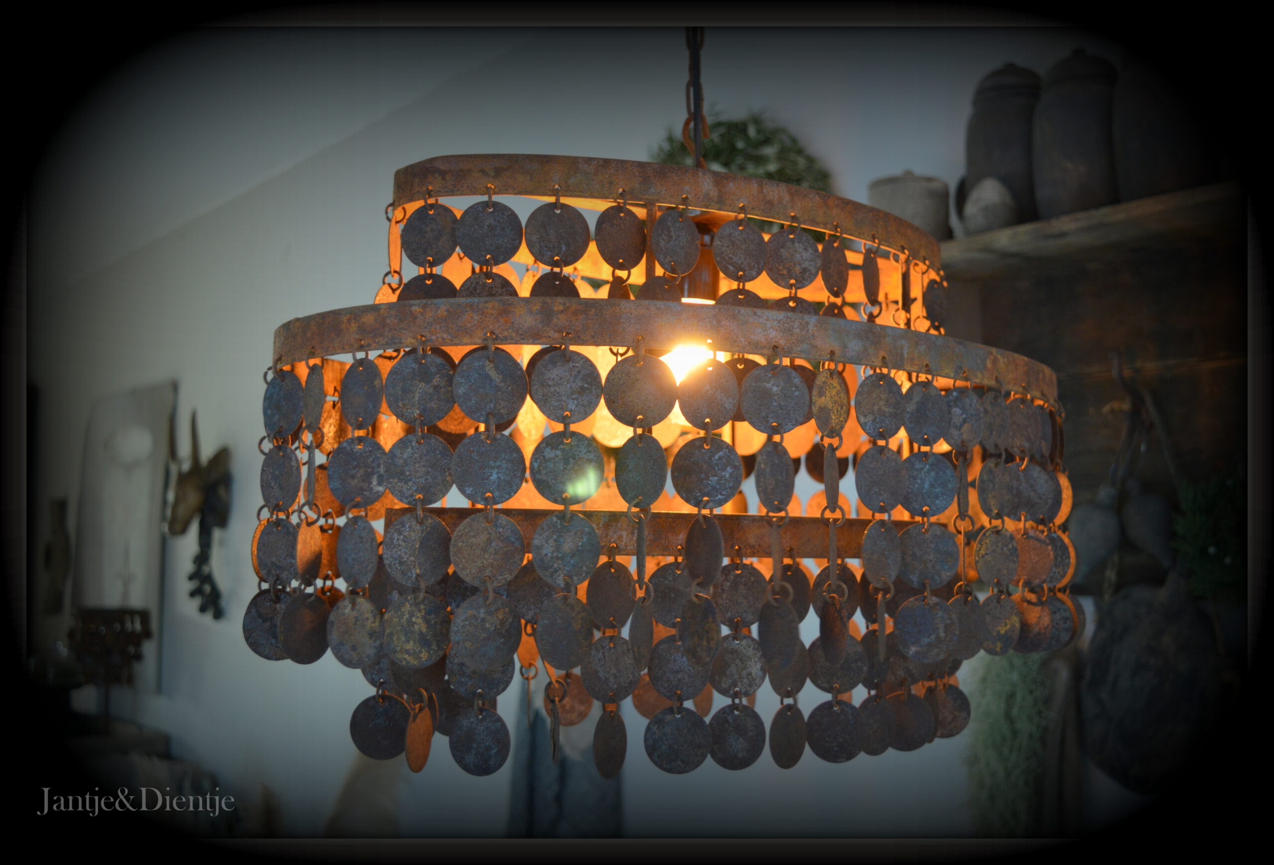 stoer en landelijk wonen. Ovale hanglamp met roestige schijfjes