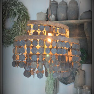 stoer en landelijk wonen. Ovale hanglamp met roestige schijfjes