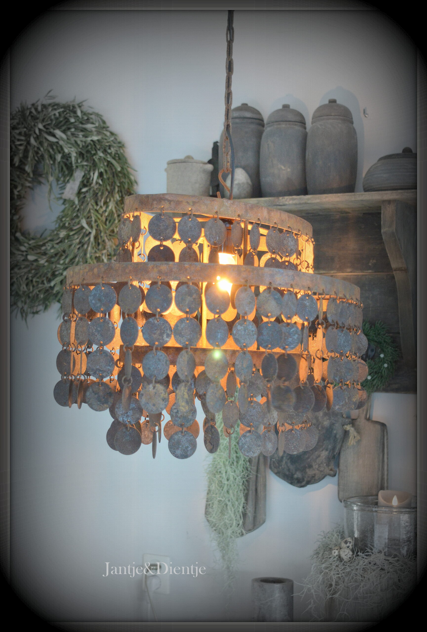 stoer en landelijk wonen. Ovale hanglamp met roestige schijfjes